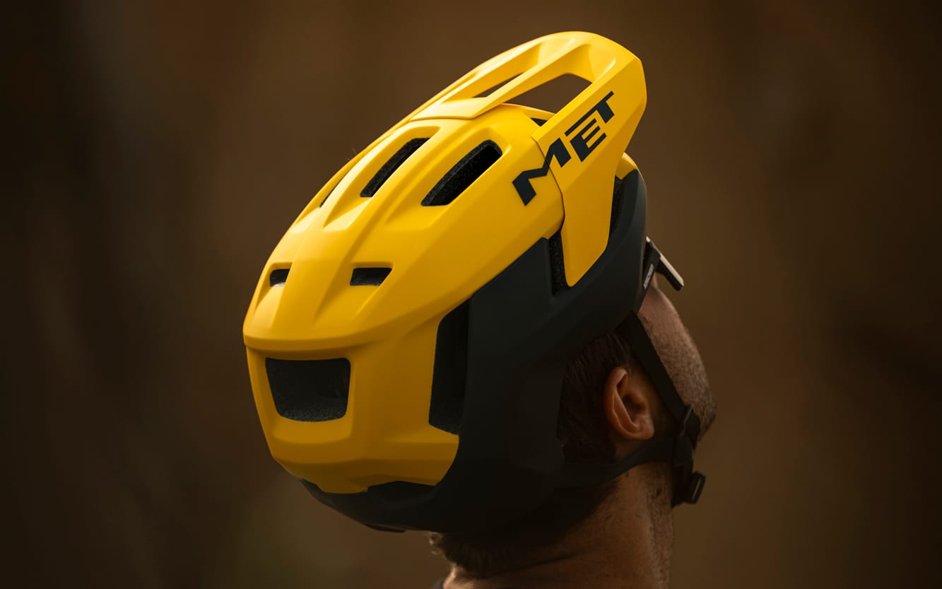 https://www.vojomag.com/app/uploads/2025/07/met terrae mips mtb helmet action image burned yellow.jpg